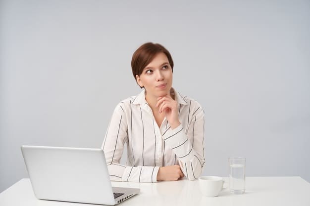 como-calcular-o-risco-de-credito. Mulher com a mão no queixo em frente ao laptop pensando.