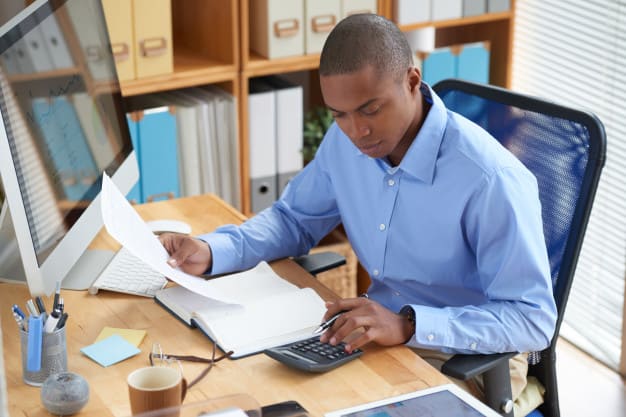 Consultar restrição cnpj.
Funcionário visualizando papeis na mesa de trabalho