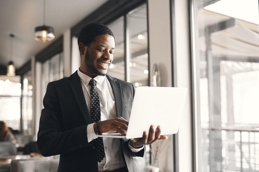 abertura de empresa, homem sorrindo digitando no computador